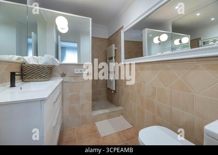 Bad mit bodenebener Dusche ohne Schirm, rutschfestem Epoxidharzboden und Fußbodenheizung Stockfoto