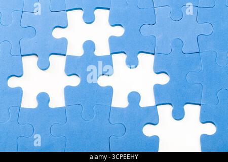 Bunte blaue Puzzleteile auf weißem Hintergrund in einem gemischten Muster angeordnet Stockfoto