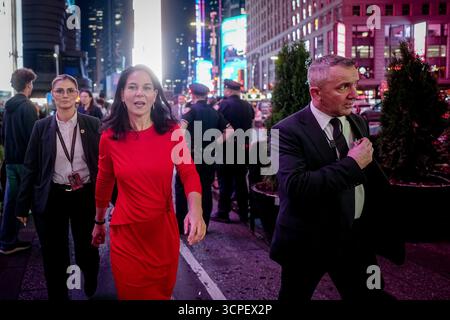 New York, USA. September 2025. Annalena Baerbock, Präsidentin der Generalversammlung der Vereinten Nationen, spaziert abends mit Leibwächtern am Times Square für ein Interview am Rande der Generaldebatte der UN-Generalversammlung in New York. Über 140 Staats- und Regierungschefs werden an der weltweit größten diplomatischen Veranstaltung über mehrere Tage teilnehmen. Quelle: Kay Nietfeld/dpa/Alamy Live News Stockfoto