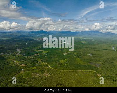 Blick aus der Vogelperspektive auf die Berge mit Regenwald und Ackerland. Tropische Landschaft und Berge. Borneo, Malaysia. Stockfoto