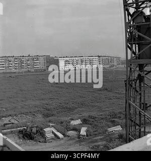 Ein Panoramablick von einer Baustelle aus zeigt die Grenze der Stadterweiterung in Sloviansk, ukrainische SSR, während der 1970er Jahre Dieses einfarbige Archivfoto erfasst ein riesiges, unbebautes Feld im Vordergrund mit einer langen Reihe neu gebauter, vorgefertigter Wohnblöcke aus der Sowjetzeit („Panelkas“) am Horizont. Die Szene auf dem Mikrobezirk Artema veranschaulicht den Prozess der Entwicklung von Massenwohnungen und der Schaffung neuer Mikrobezirke in der UdSSR Stockfoto