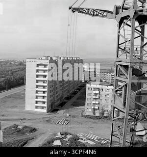 Ein Blick von einem Baukran überblickt ein neues Wohnviertel, das in den 1970er Jahren auf dem Artema Mikrodistrikt in Sloviansk, ukrainische SSR, gebaut wurde Diese monochrome Archivserie erfasst den Prozess der massenhaften sowjetischen Wohnentwicklung und zeigt neu errichtete Plattenwohnblöcke („Panelkas“). Die Szene mit Baumaterialien am Boden verkörpert die rasante Urbanisierung der damaligen Zeit in der industriellen Donbass-Region Stockfoto