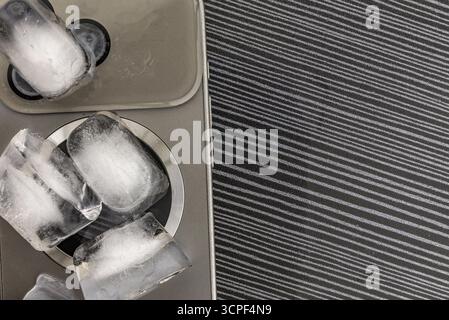 Das Konzept der Überhitzung und Brandgefahr. Kühlung des neuesten Smartphones mit Eiswürfeln. Zu hohe Betriebstemperatur des Prozessors beschädigt das iPhone Stockfoto