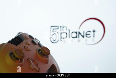 Dhaka, Bangladesch, 23. September 2025: Eine Nahaufnahme eines Gamepads mit den Spielen des 5. Planeten, die im Hintergrund auf dem Bildschirm zu sehen sind Stockfoto