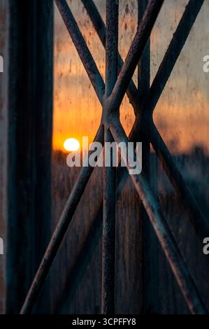 Rostige Fenster Metallstangen reflektieren bei Sonnenaufgang - degradierte Stadt Stockfoto
