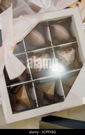Verlieren Sie eine Geschenkbox mit Süßigkeiten in Form von Herzen und Pyramiden. Eine Schachtel handgemachte Pralinen Stockfoto