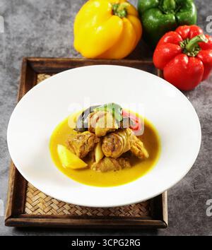 Thailändisches gelbes Curry-Huhn mit Paprika auf weißer Platte Stockfoto