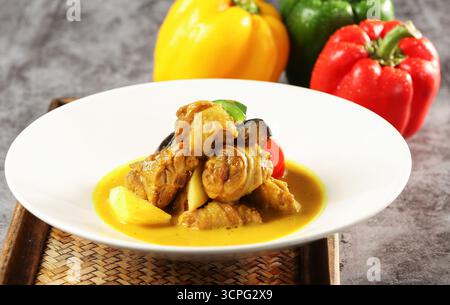 Thailändisches gelbes Curry-Huhn mit Paprika auf weißer Platte Stockfoto