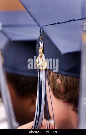 Nahaufnahme, Rückansicht von männlichen Schülern in Abschlussmützen und -Kleidern, die auf ihre Diplome bei ihrem Abschluss warten. Stockfoto