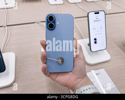 Posen, Polen – 20. September 2025: Blaues Smartphone des iPhone 17 mit Apple-Logo im Elektronikgeschäft, das von einem Kunden gehalten wird und die mobile Technologie demonstriert Stockfoto