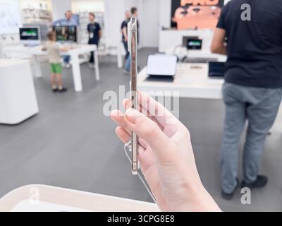 Poznan, Polen – 20. September 2025: Das iPhone Air wurde von einer Hand in einer lebhaften Einzelhandelsumgebung demonstriert und betont die Benutzererfahrung mit innovativ Stockfoto