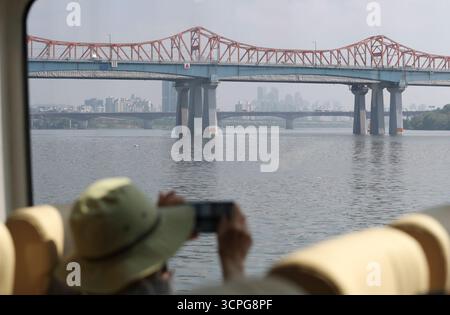 Seoul, Südkorea. September 2025. Ein Tourist genießt die Landschaft des Han Flusses in einem „Hangang Bus“ in Seoul, Südkorea, 26. September 2025. Seoul hat kürzlich den „Hangang Bus“ auf den Markt gebracht. Einwohner und Touristen, die den „Hangang Bus“ nehmen, können die Landschaft von Seoul entlang des Han Flusses genießen. Quelle: Yao Qilin/Xinhua/Alamy Live News Stockfoto