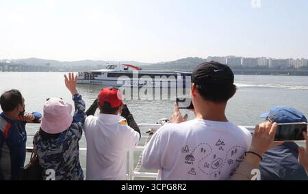 Seoul, Südkorea. September 2025. Touristen in einem „Hangang Bus“ begrüßen einen anderen „Hangang Bus“, der am 26. September 2025 in Seoul, Südkorea, vorbeifährt. Seoul hat kürzlich den „Hangang Bus“ auf den Markt gebracht. Einwohner und Touristen, die den „Hangang Bus“ nehmen, können die Landschaft von Seoul entlang des Han Flusses genießen. Quelle: Yao Qilin/Xinhua/Alamy Live News Stockfoto