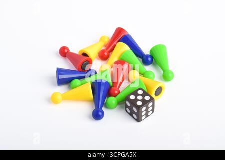 Bunte Brettspiel-Figuren und Würfel isoliert auf weißem Hintergrund Stockfoto