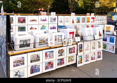 Kunststand im Freien mit einer Vielzahl von bunten Drucken und Gemälden, die in einem Park zum Verkauf stehen. New york City manhattan Stockfoto