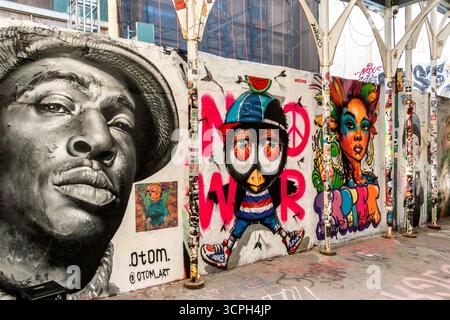 Städtisches Graffiti an der Wand mit farbenfroher Street Art, Porträt, Cartoon-Charakter und abstraktem Design von Otom in der Freemans Allee Bowery New York City NY Stockfoto