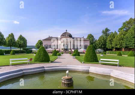 Melk, Österreich - 5. Juni 2022: Eine majestätische Abtei erhebt sich anmutig inmitten üppiger Gärten mit beschnittenen Hecken und lebendigen Bäumen unter einem sonnigen blauen Himmel Stockfoto