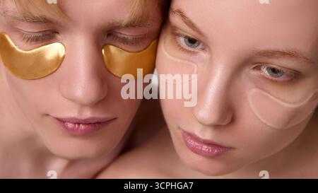 Zartes Porträt von Mann und Frau, die Hydrogelpflaster für die Augenpflege tragen Stockfoto