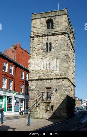 Morpeth historischer Uhrenturm aus Stein mit Bogenfenstern und Treppen neben lebendigen roten Backsteingebäuden an einem sonnigen Tag in Northumberland Stockfoto