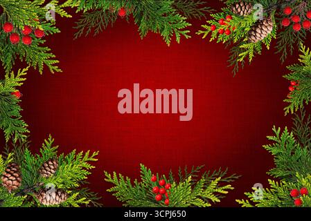Feiertagshintergrund mit immergrünen Zweigen, Tannenzapfen und Beeren auf roter Leinwand. Stockfoto
