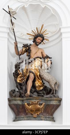 SALZBURG, AUSTIRA - 8. SEPTEMBER 2025: Die geschnitzte polychrome Barockstatue des heiligen Johannes des Täufers in der Kirche Kollegienkirche Stockfoto