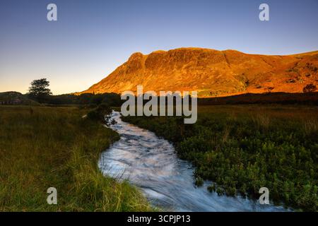 Der Bach fließt am frühen Morgen mit Licht auf dem Hügel Stockfoto
