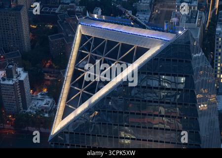 Blick auf die geometrisch markante Glasfassade des bei Dämmerung beleuchteten Gebäudes VIA 57 West, das moderne Architektur mit der pulsierenden Stadt New Y verbindet Stockfoto