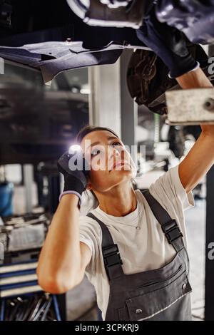 Ein erfahrener Mechaniker inspiziert ein Fahrzeug sorgfältig mit außergewöhnlicher Präzision und Sorgfalt Stockfoto