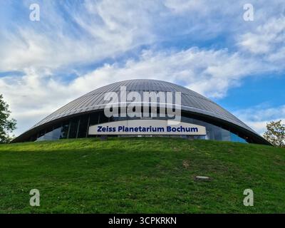 Bochum, Deutschland - 25. September 2025: Zeiss Planetarium Bochum Kuppel über grüner Parklandschaft, moderne geschwungene Architektur in Deutschland, ein Wahrzeichen für Stockfoto