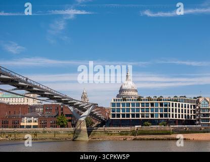 LONDON, ENGLAND – 28. August 2025: Die Hungerford Bridge überquert die Themse, dahinter erhebt sich das Shell Mex House, eine Fusion aus Londons historischem Archit Stockfoto