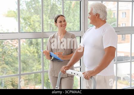 Seniorenausbildung bei Therapeuten auf Laufband im Rehabilitationszentrum Stockfoto