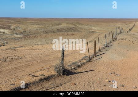 Trockene Landschaft in der Nähe von Coober Pedy, South Australia, mit einem Abschnitt des Dingo Fence. Stockfoto