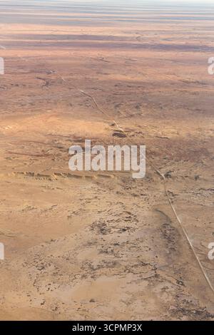 Aus der Vogelperspektive einer ländlichen Feldstraße, die sich durch die trockene Wüstenlandschaft rund um William Creek, South Australia, erstreckt. Stockfoto