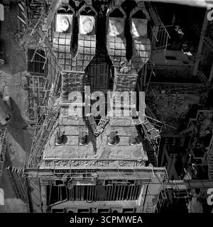 Eine Ansicht von oben nach unten zeigt die symmetrische, brutalistische Architektur einer Industrieeinheit, die in einer Kalk- und Kalkfabrik in Shyldiwka, der ukrainischen SSR, in den 1970er Jahren gebaut wurde Dieses atemberaubende monochrome Archivfoto zeigt die komplexe und fast abstrakte Geometrie der Fabrikmaschinen, eine Perspektive, die man nicht vom Boden aus gesehen hat. Das Bild ist ein eindrucksvolles Zeugnis des monumentalen Umfangs und der komplizierten Ingenieurskunst der sowjetischen Schwerindustrie im Donbass. Stockfoto