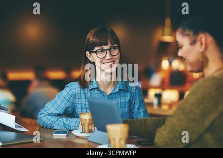 Treffen, Unternehmen und Menschen im Café mit Tablet, Konversation und Zusammenarbeit für Feedback. Planung, Teamarbeit und Fernarbeit im Restaurant Stockfoto