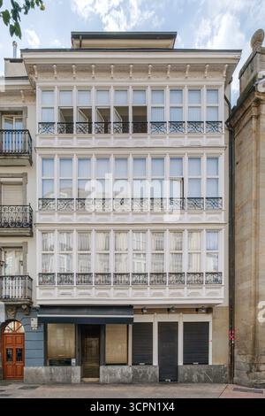 Traditionelles baskisches Architekturgebäude mit weißen Balkonen in Vitoria Gasteiz Spanien. Historische Fassade, Eisenwerk, klassisches Design, urbanes Erbe Stockfoto