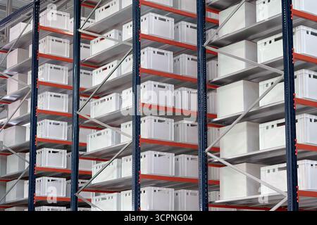 Generische weiße unbeschriftete Kisten und Kisten auf Regalen eines Lagerregals, abstrakter industrieller Hintergrund Stockfoto
