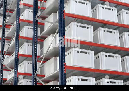 Generische weiße unbeschriftete Kisten und Kisten auf Regalen eines Lagerregals, abstrakter industrieller Hintergrund Stockfoto