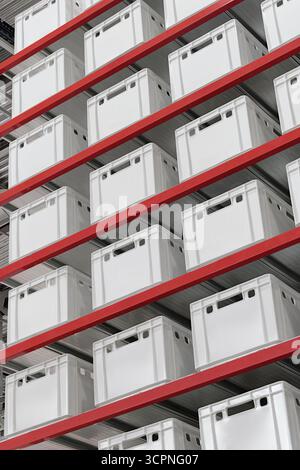 Generische weiße unbeschriftete Kisten und Kisten auf Regalen eines Lagerregals, abstrakter industrieller Hintergrund Stockfoto
