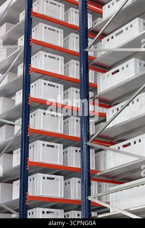 Generische weiße unbeschriftete Kisten und Kisten auf Regalen eines Lagerregals, abstrakter industrieller Hintergrund Stockfoto