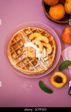 Hausgemachte belgische Waffeln mit frischen Pfirsichen und Sahne, selektiver Fokus Stockfoto