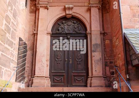 Heidelberg, Deutschland - 8. Juni 2025: Nahaufnahme einer detaillierten Holztür mit kunstvollen Schnitzereien an einem historischen Heidelberger Gebäude mit Rost Stockfoto