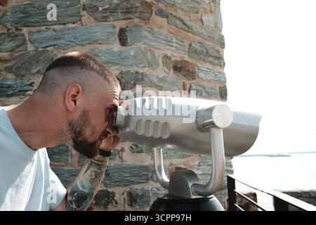 Ein Mann, der die Donau von der RAM-Festung aus durch einen öffentlichen Fernblick beobachtet. Ein beliebtes Touristenziel in Serbien Stockfoto