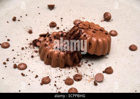 Köstliche Schokoladendesserts umgeben von Schokoladenbröseln. Dieses verführerische Bild fängt die reichhaltigen Texturen und den verwöhnenden Reiz von Schokolade ein. Stockfoto