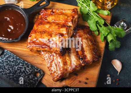 Scharfe heiße gegrillte Spare Ribs vom Sommer-BBQ serviert mit heißem Chili und frischen Tomaten Stockfoto