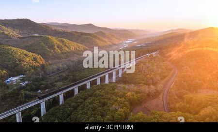Suifenhe. September 2025. Ein Luftdrohnenfoto vom 27. September 2025 zeigt einen Güterzug, der entlang des neu ausgebauten Abschnitts einer Eisenbahnstrecke fährt, die Suifenhe mit der chinesisch-russischen Grenze in der nordöstlichen chinesischen Provinz Heilongjiang verbindet. Am Samstag wurde ein umfangreicher Ausbau einer Eisenbahnstrecke zwischen Suifenhe und der chinesisch-russischen Grenze abgeschlossen, wobei neue Gleise in Betrieb genommen wurden, die es ermöglichen, mit Geschwindigkeiten von bis zu 120 km/h zu fahren, was mehr als dem Doppelten der bisherigen Grenze von 55 km/h entspricht, wodurch die Transportkapazität erheblich gesteigert wurde. Quelle: Qu Yiwei/Xinhua/Alamy Live News Stockfoto