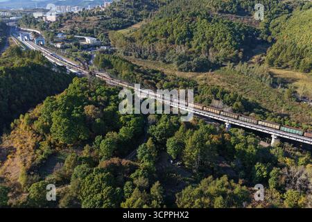Suifenhe. September 2025. Ein Luftdrohnenfoto vom 27. September 2025 zeigt einen Güterzug, der entlang des neu ausgebauten Abschnitts einer Eisenbahnstrecke fährt, die Suifenhe mit der chinesisch-russischen Grenze in der nordöstlichen chinesischen Provinz Heilongjiang verbindet. Am Samstag wurde ein umfangreicher Ausbau einer Eisenbahnstrecke zwischen Suifenhe und der chinesisch-russischen Grenze abgeschlossen, wobei neue Gleise in Betrieb genommen wurden, die es ermöglichen, mit Geschwindigkeiten von bis zu 120 km/h zu fahren, was mehr als dem Doppelten der bisherigen Grenze von 55 km/h entspricht, wodurch die Transportkapazität erheblich gesteigert wurde. Quelle: Wang Song/Xinhua/Alamy Live News Stockfoto