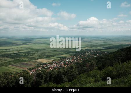 Großer Panoramablick auf Vrsac und die umliegende serbische Landschaft unter einem dramatischen bewölkten Himmel im Frühling. Stockfoto