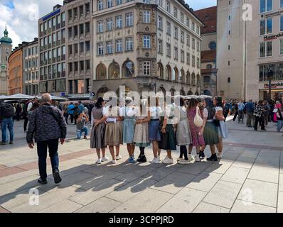 München, Deutschland. September 2025. Besucher in traditionellen Dirndl-Kleidern posieren für Fotos am Marienplatz in München, Bayern, Deutschland, am 27. September 2025. Die Gruppe feiert das Oktoberfest in der Innenstadt, bevor es zum Festgelände geht. (Foto: Michael Nguyen/NurPhoto) Credit: NurPhoto SRL/Alamy Live News Stockfoto