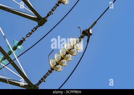 Nahaufnahme der Isolatoren an Hochspannungsleitungen an Pylonen, die das nationale Stromnetz und das Stromversorgungssystem in Großbritannien bilden Stockfoto